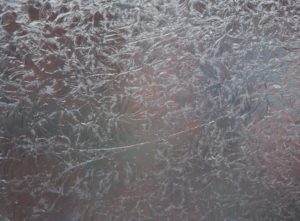 A close up of a window with frost on it.